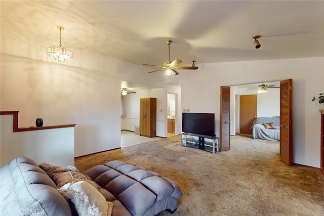 living room with lofted ceiling, light carpet, and ceiling fan with notable chandelier