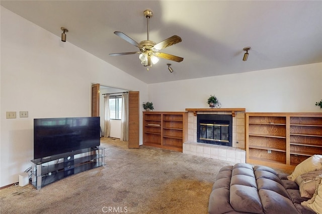 carpeted living room with ceiling fan, vaulted ceiling, and a fireplace