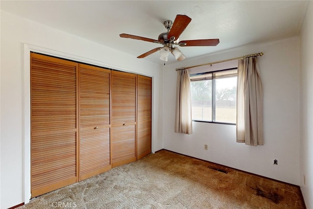 unfurnished bedroom with carpet floors, a closet, and ceiling fan