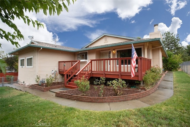 rear view of house with a deck and a lawn