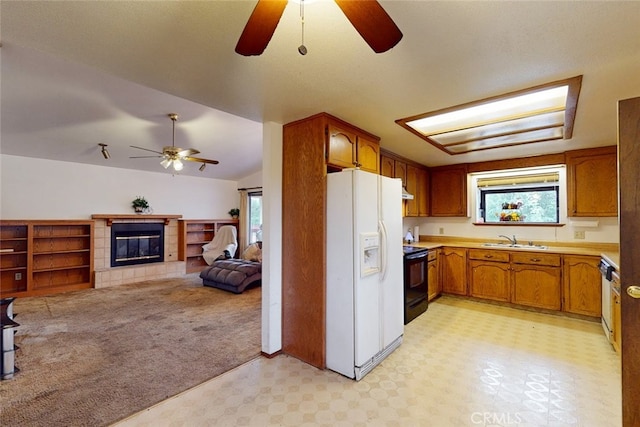 kitchen with lofted ceiling, a healthy amount of sunlight, sink, and white refrigerator with ice dispenser