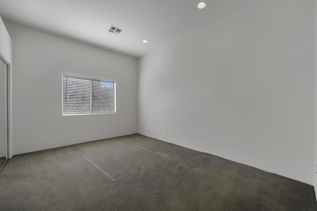 unfurnished room featuring dark colored carpet