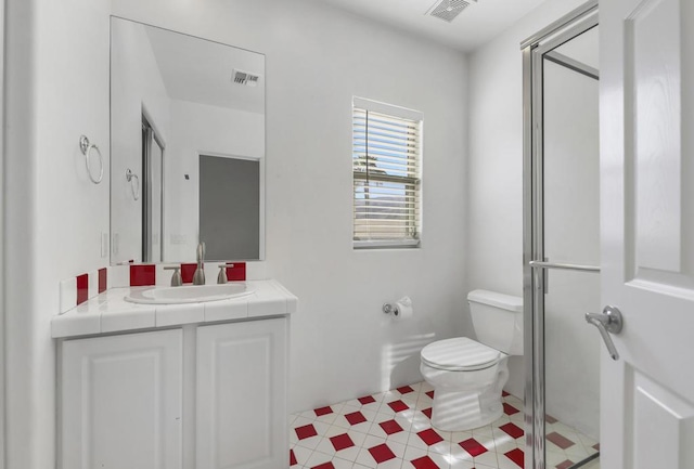 bathroom with vanity, a shower with shower door, and toilet