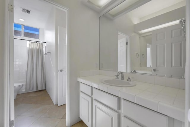 bathroom with tile patterned flooring, vanity, and toilet