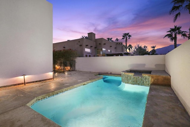 pool at dusk with a patio area