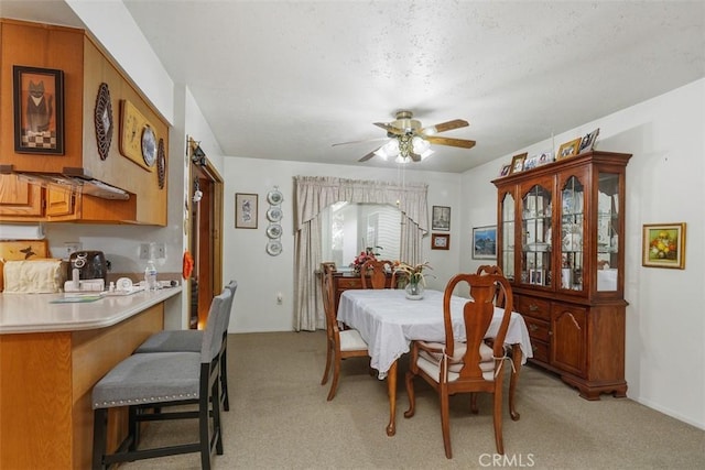 dining room with ceiling fan and light colored carpet