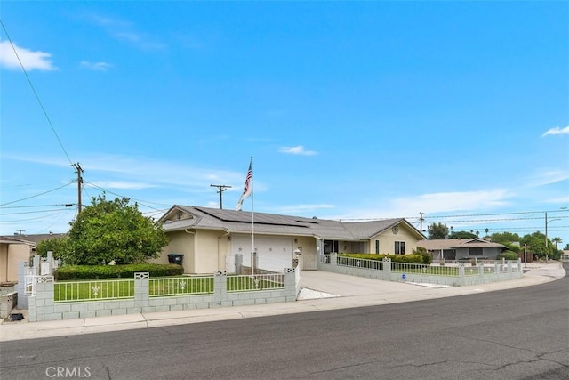 ranch-style home featuring a garage and solar panels