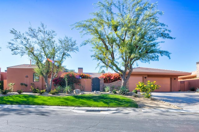 view of front of home with a garage and a front lawn