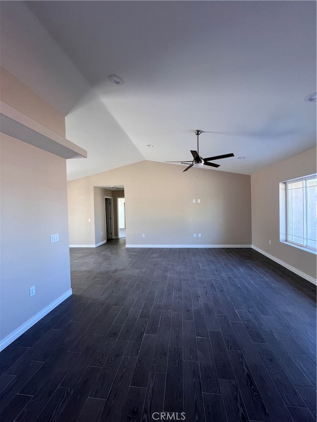 empty room with dark wood finished floors, lofted ceiling, baseboards, and ceiling fan