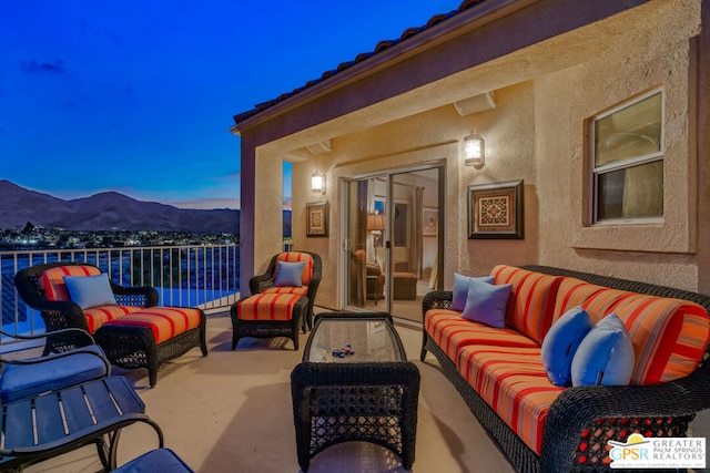 patio terrace at dusk featuring an outdoor living space and a water and mountain view