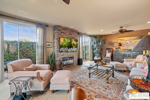 tiled living room featuring ceiling fan, a healthy amount of sunlight, and a fireplace