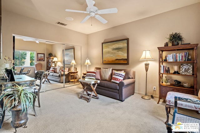 carpeted living room with ceiling fan