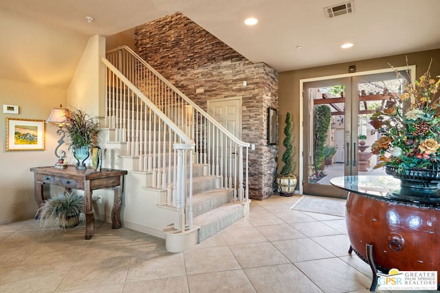 entrance foyer featuring french doors, a high ceiling, and light tile patterned floors