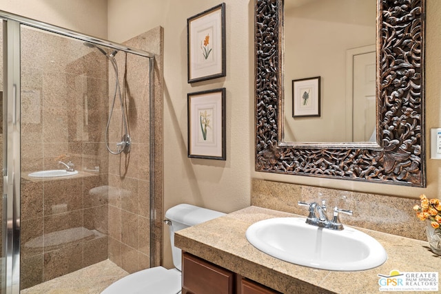 bathroom with vanity, a shower with shower door, and toilet