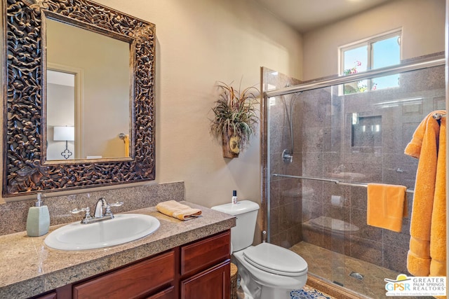 bathroom with toilet, a shower with door, and vanity