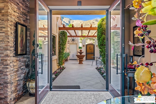 doorway to outside with a mountain view and light tile patterned floors