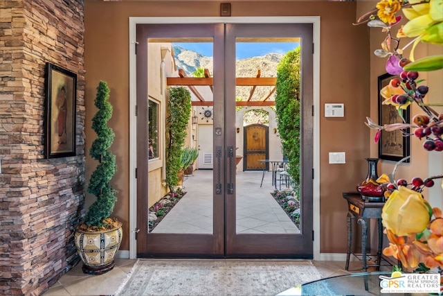 doorway with french doors and light tile patterned floors