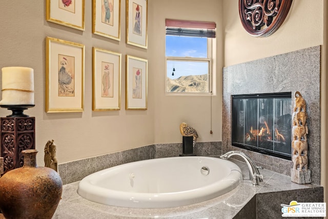 bathroom featuring a premium fireplace and a relaxing tiled tub