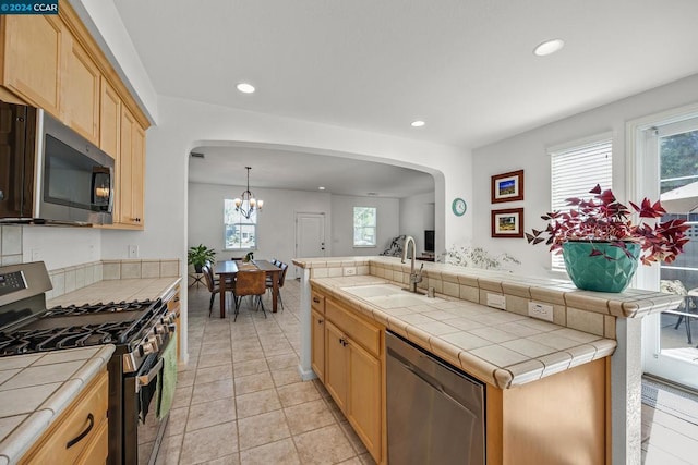 kitchen featuring sink, appliances with stainless steel finishes, tile counters, and a healthy amount of sunlight