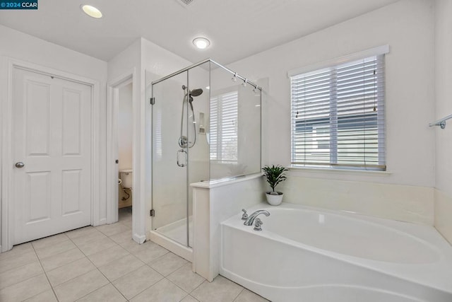 bathroom featuring separate shower and tub, toilet, and tile patterned flooring