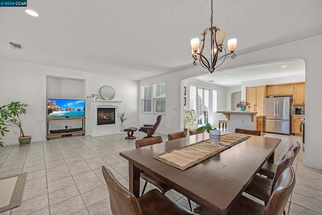 tiled dining area with a chandelier