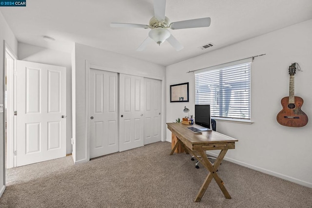 carpeted office space with ceiling fan