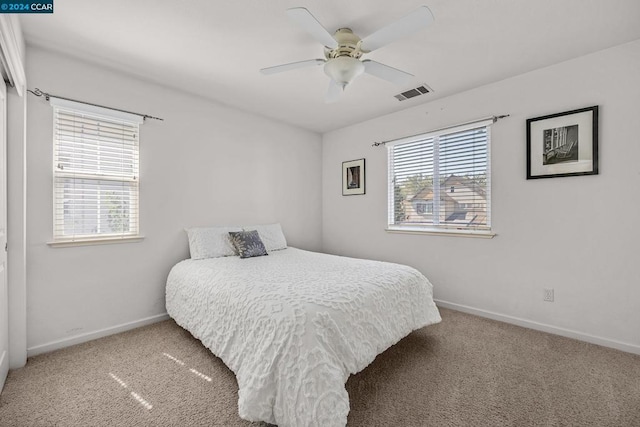 carpeted bedroom with ceiling fan and multiple windows