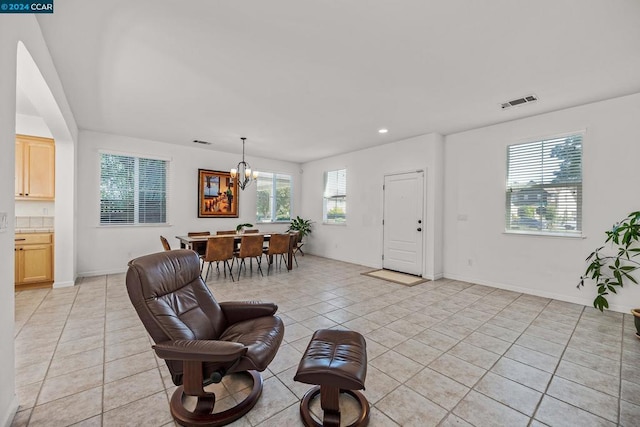 tiled living room featuring an inviting chandelier