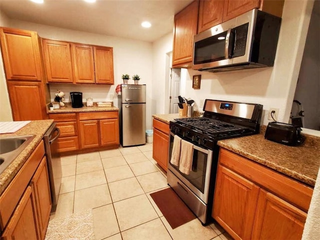 kitchen featuring light tile patterned floors, stainless steel appliances, and stone countertops