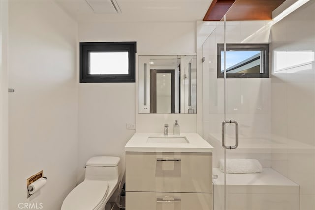 bathroom featuring toilet, an enclosed shower, and vanity