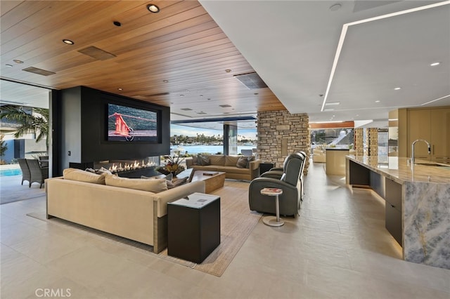 living room featuring a wall of windows, sink, and wooden ceiling