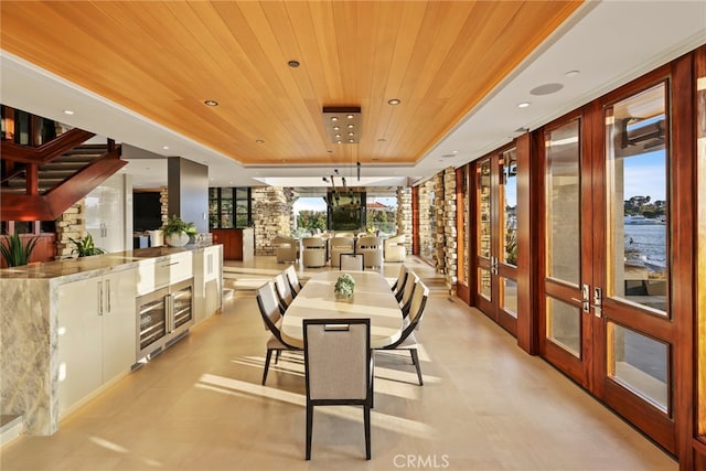 dining space featuring a water view, wood ceiling, and french doors