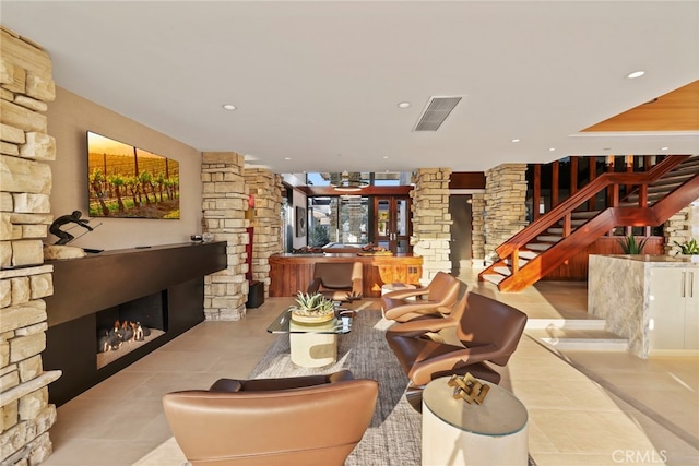 living room with decorative columns and light tile patterned flooring