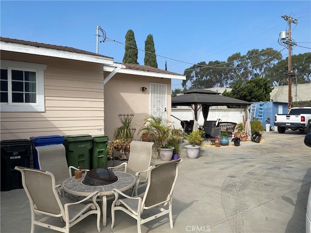 view of patio featuring a gazebo and a fire pit