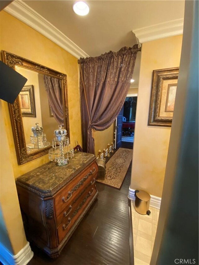 hall featuring dark tile patterned floors and crown molding