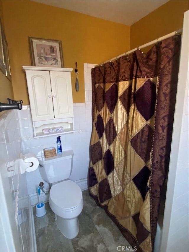 bathroom with tile walls, toilet, and a shower with shower curtain