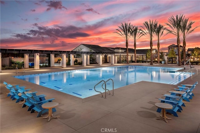 pool at dusk with a patio area