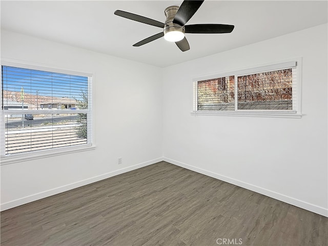 empty room with ceiling fan and dark hardwood / wood-style flooring