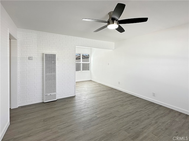 empty room with dark wood-type flooring and ceiling fan