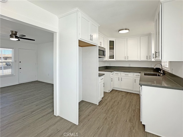 kitchen with ceiling fan, light hardwood / wood-style floors, sink, and white cabinets