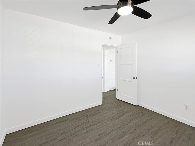 spare room featuring dark wood-type flooring and ceiling fan