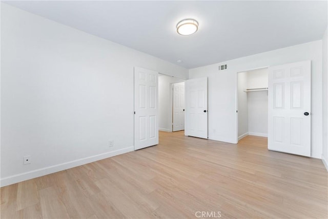 unfurnished bedroom with a closet and light hardwood / wood-style floors