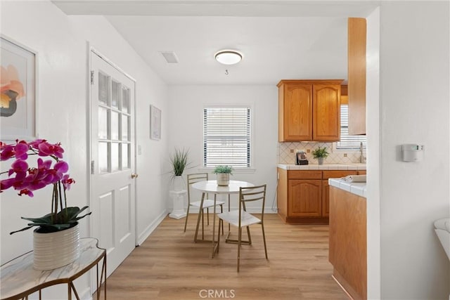 kitchen featuring tasteful backsplash and light hardwood / wood-style flooring