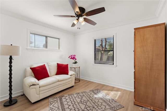 living area with light hardwood / wood-style flooring, ceiling fan, and ornamental molding