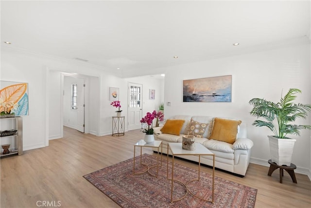 living room featuring light wood-type flooring and ornamental molding