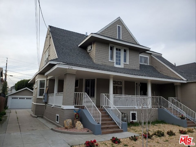 view of front of home featuring a porch, a garage, and an outdoor structure