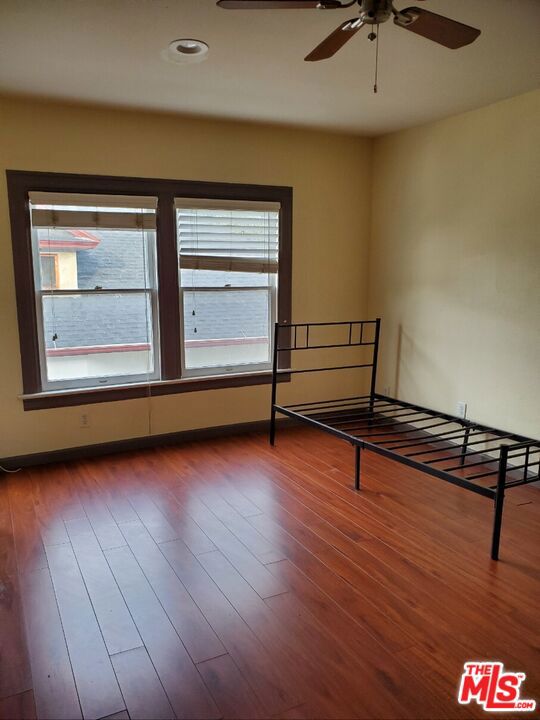 unfurnished bedroom featuring hardwood / wood-style flooring and ceiling fan