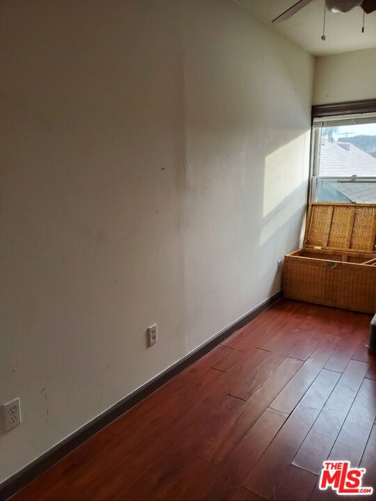 unfurnished room with dark hardwood / wood-style flooring and ceiling fan