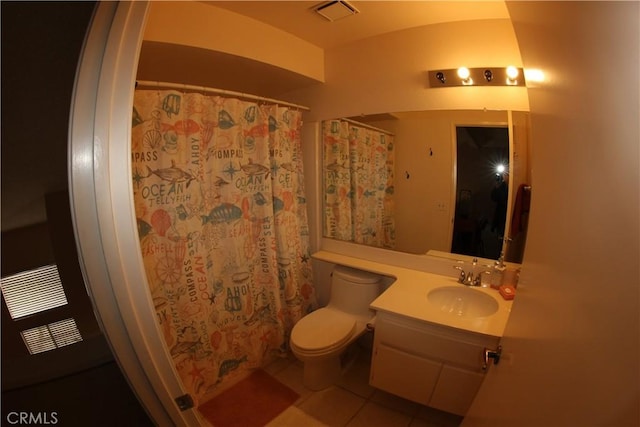 bathroom with toilet, vanity, tile patterned floors, and walk in shower