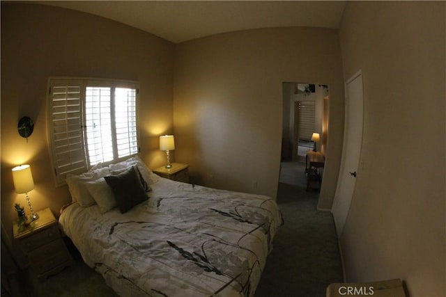 carpeted bedroom with lofted ceiling